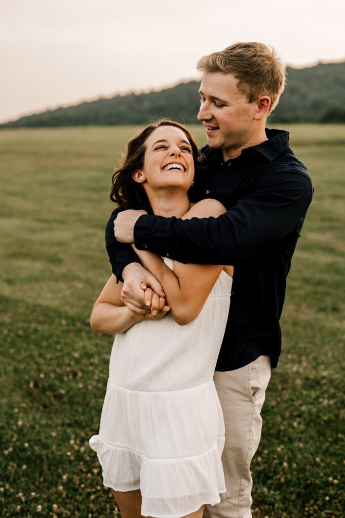 Young couple summer engagement session in June. open field in Asbury, New Jersey. Fun carefree and candid photography. New Jersey Photographer