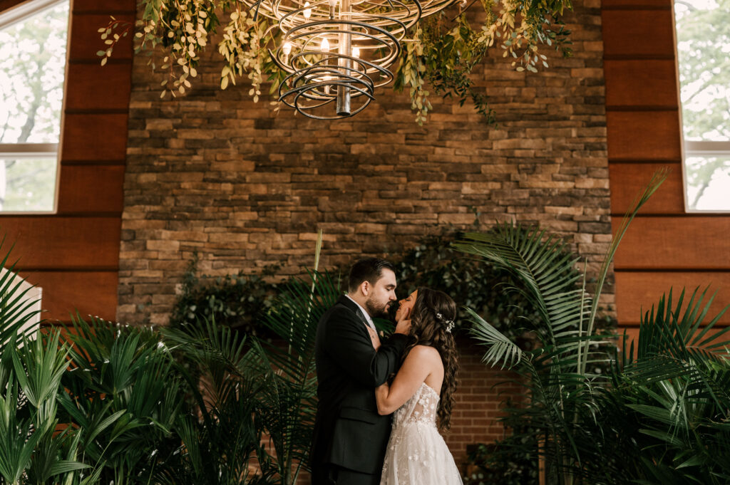 bride and groom surrounded by botanical plants at stone house at stirling ridge in warren new jersey