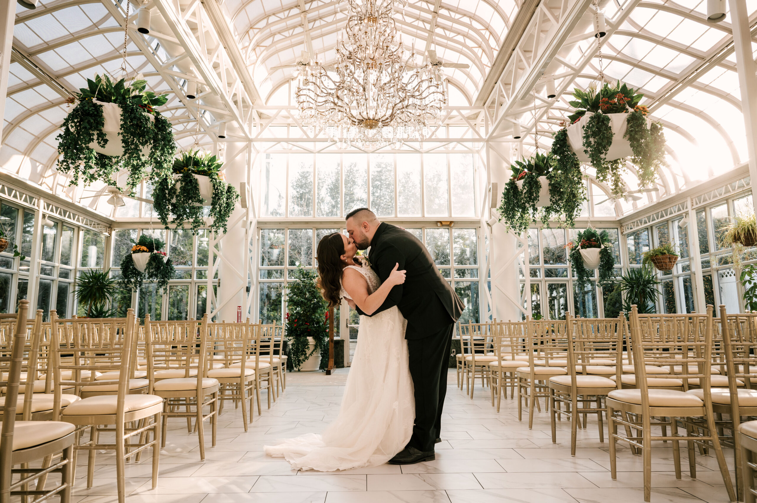 bride and groom kiss and dip inside the atrium ceremony space at Madison Hotel in New Jersey for their March wedding