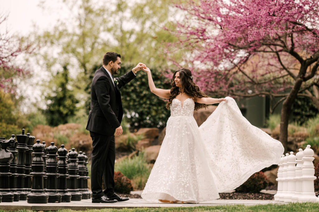 bride and groom dancing on the big chess board during spring time at stone house at stirling ridge in warren new jersey