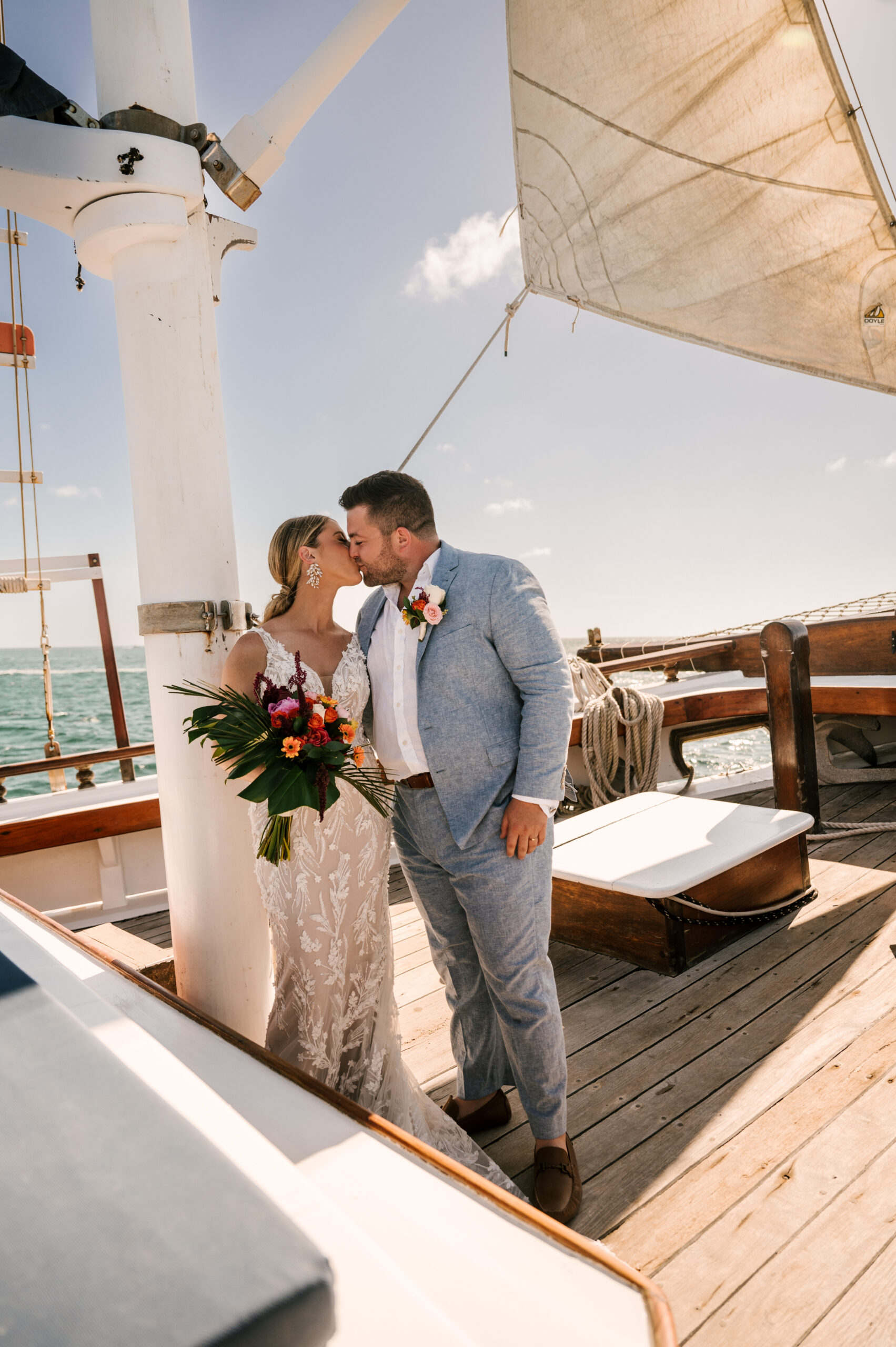Aruba Marriott Resort Stellaris Casino sailboat ceremony wedding Pelican adventures tropical island destination wedding bride and groom kissing on the ocean