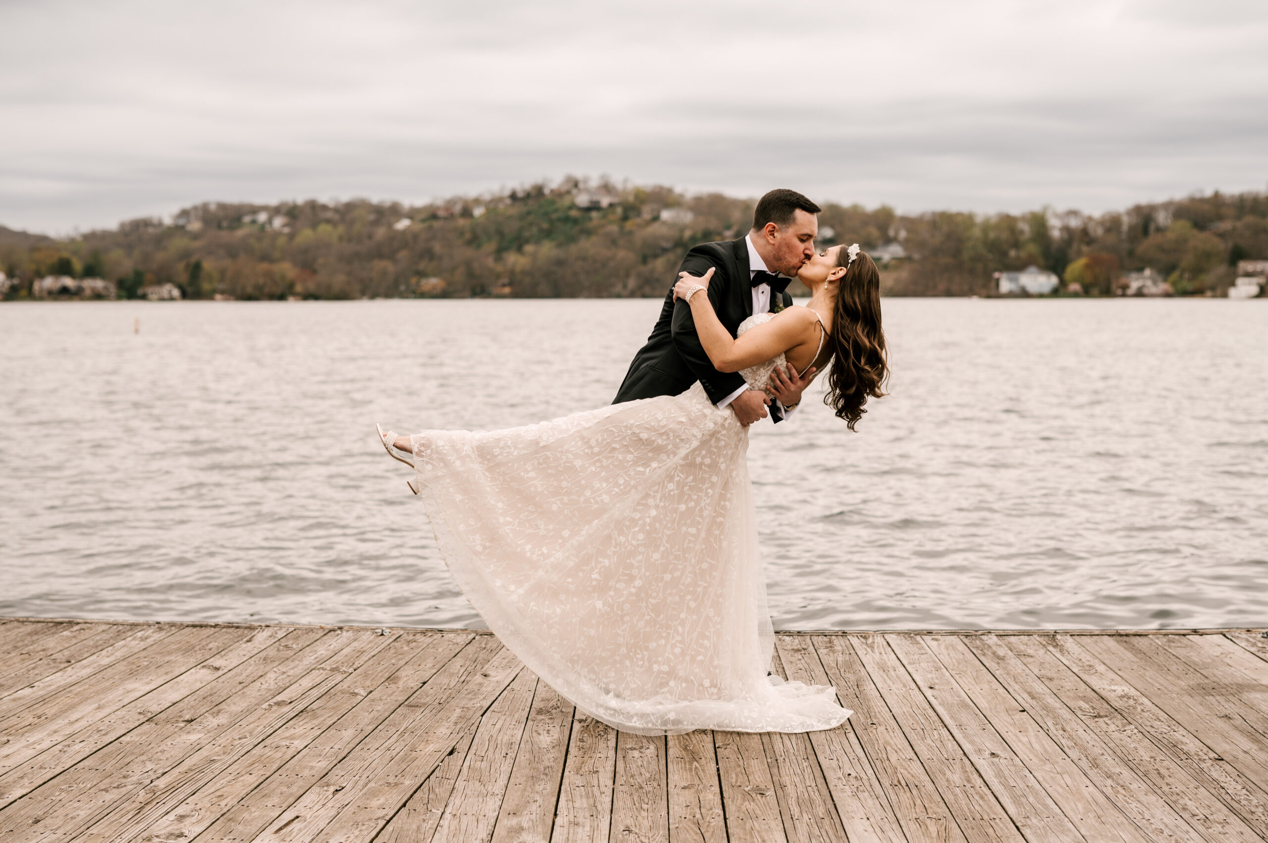 Bride and groom in love dance with a dip and a kiss on the boardwalk by the lake at Lake Mohawk Country Club in Sparta, New Jersey