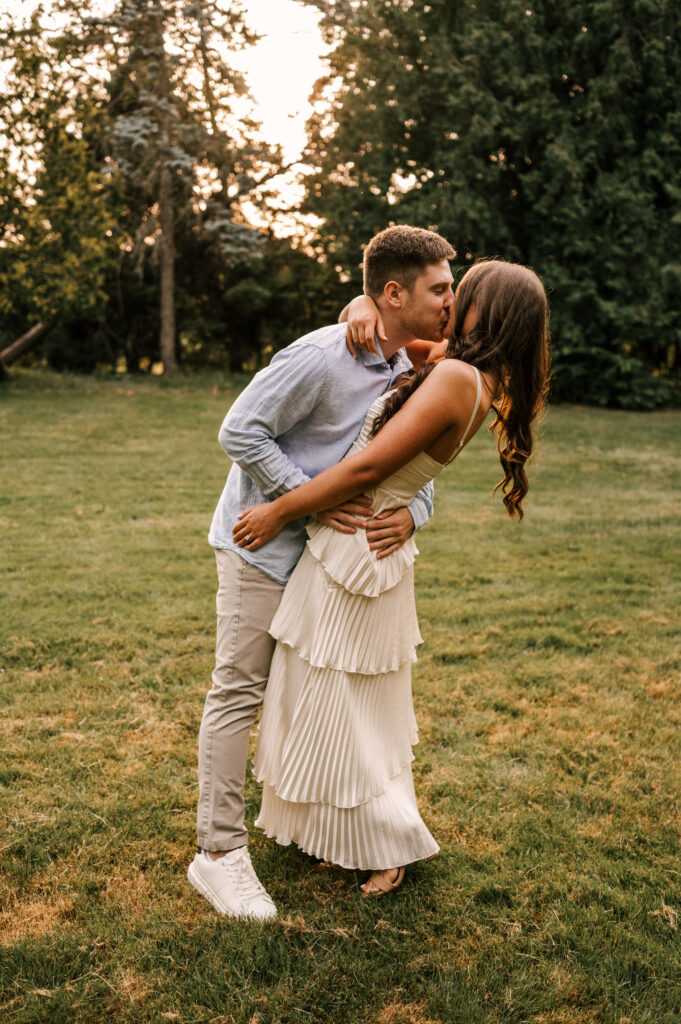 The groom-to-be leans in for a kiss with his fiancée at Skylands Manor in Ringwood, NJ.