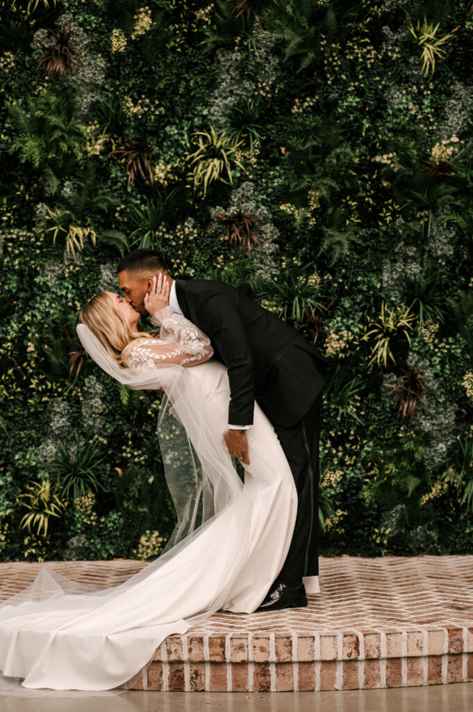 The couple embrace and share their first kiss as husband and wife at their ceremony at the Refinery at Perona Farms.