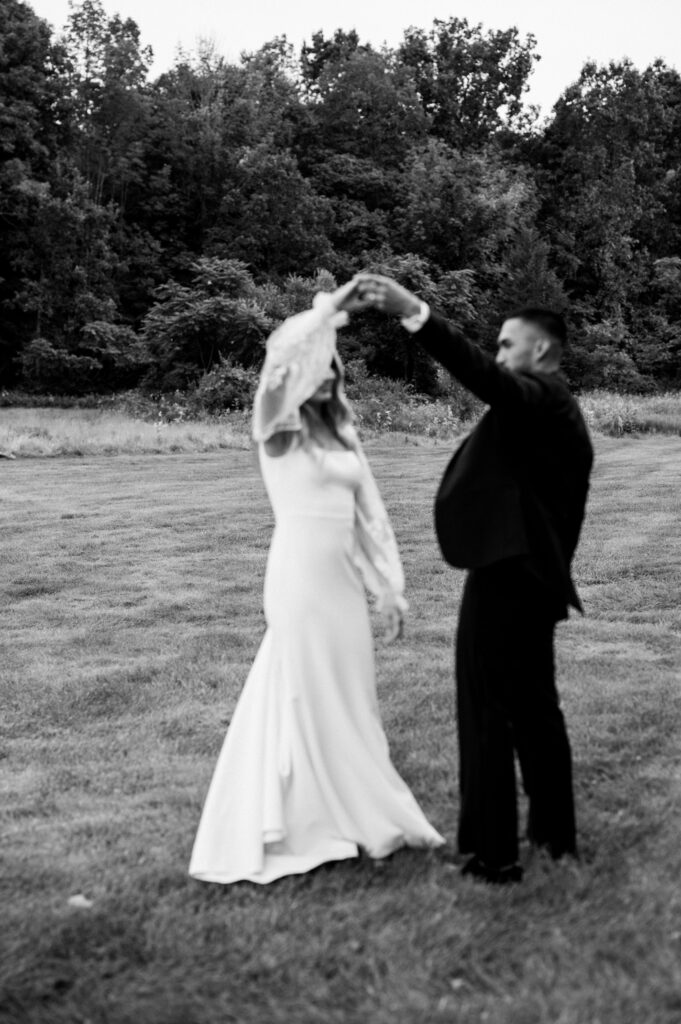 The bride and groom dancing after the ceremony in a field at Perona Farms.