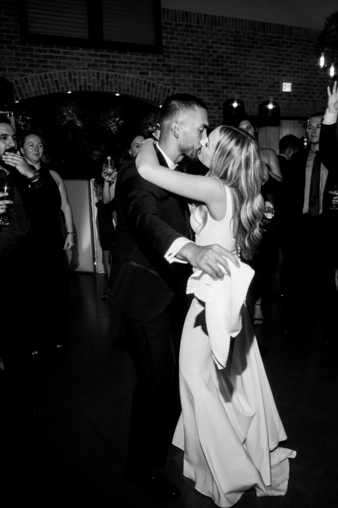 The newlyweds kissing on the dance floor at the reception at the Refinery at Perona Farms.