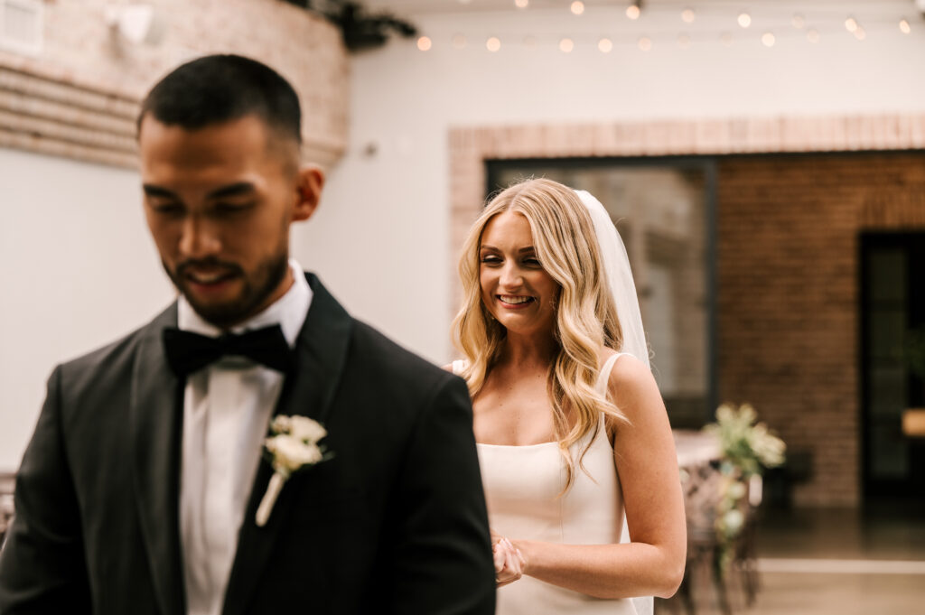 The bride and groom anxiously awaiting their first look in the ceremony space at Perona Farms.