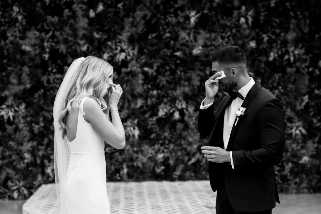 The bride and groom getting emotional and wiping away tears after their first look.