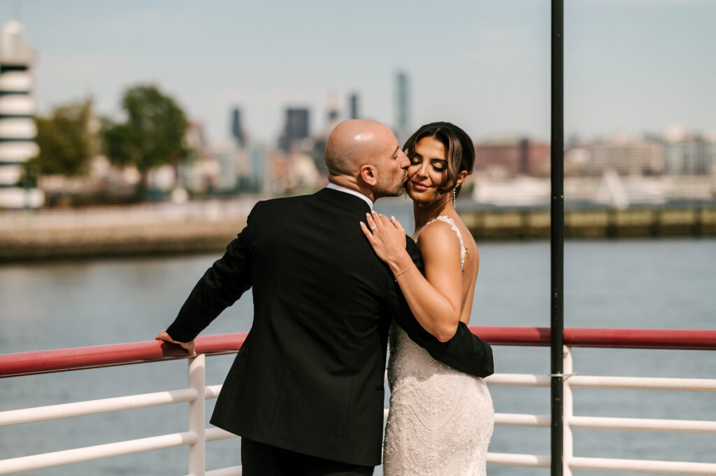 Groom kidding the bride on the cheek on the pier at Battello.