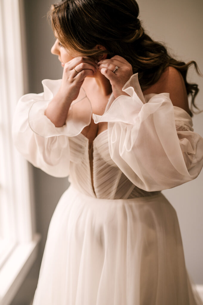 The bride putting her earrings on before the ceremony at the Ryland Inn.
