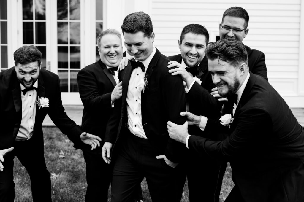 The groomsmen laughing and cheering on the groom at the Ryland Inn.