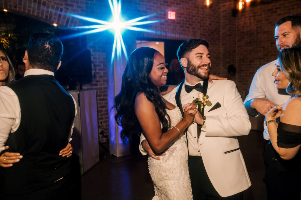 The newlyweds dancing as they talk to guests at the reception at Perona Farms Refinery.