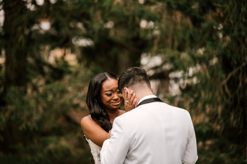 The couple sharing an intimate moment as the bride cups his face and cries.