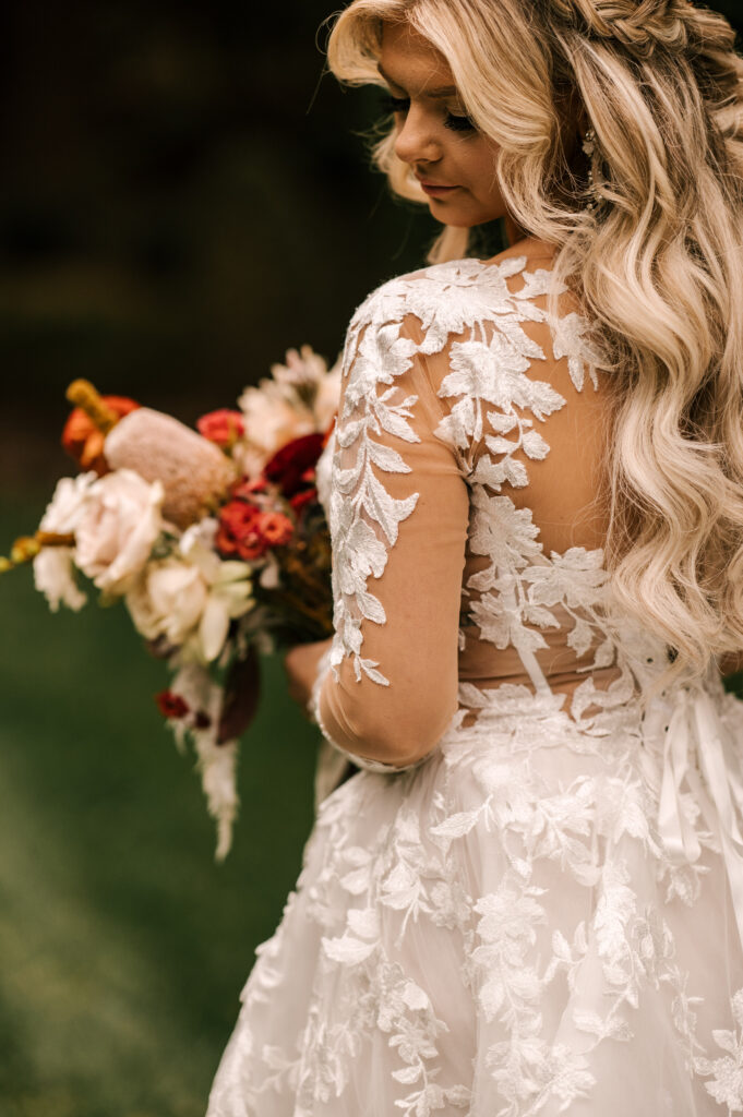 The bride serenely looking over her shoulder as she holds her bouquet at Ashford Estate.