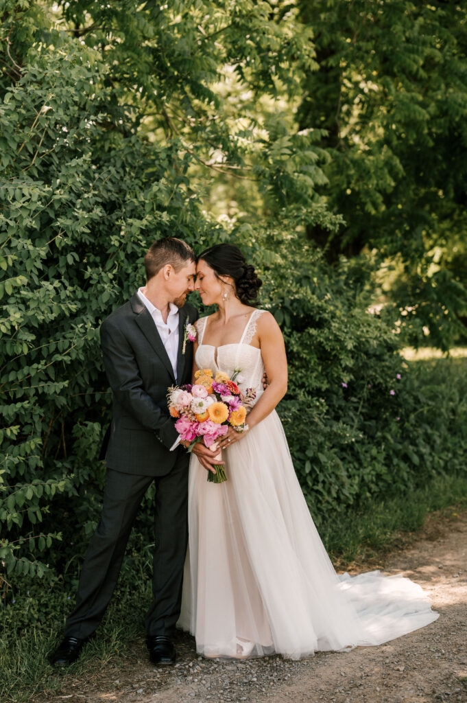The couple peacefully nuzzling their heads together as they hold the bride's bouquet at Wallenpaupack Creek Farm.