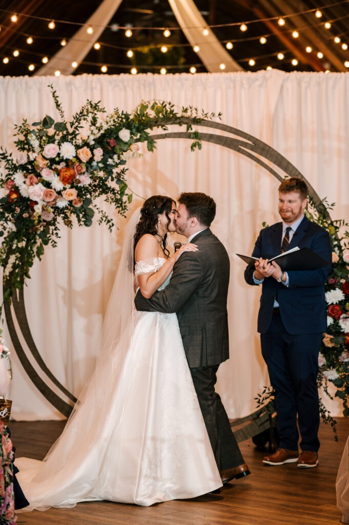 The couple's first kiss as husband and wife at The Barn at Perona Farms.