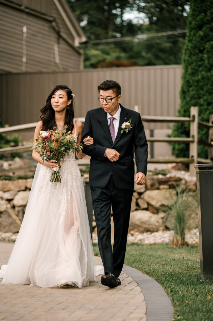 The bride's father walking her down the aisle for the ceremony at Rock Island Lake Club.