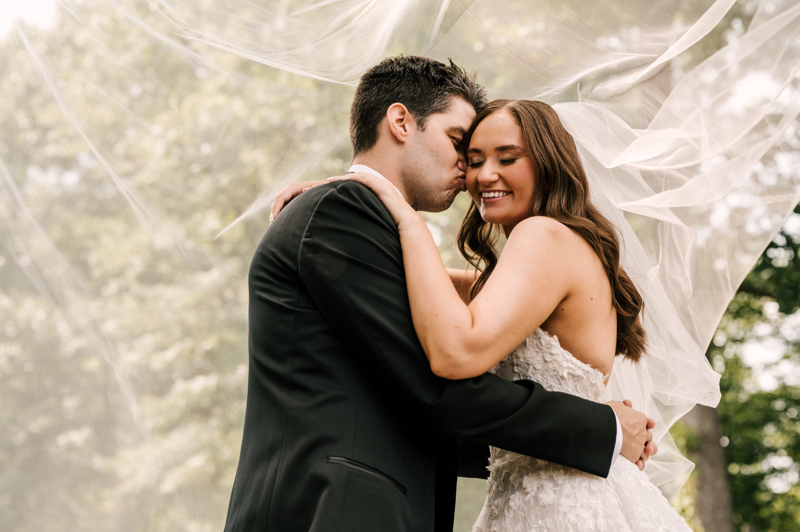 Bride and groom snuggled up under the bride's veil at the Perona Farms Refinery