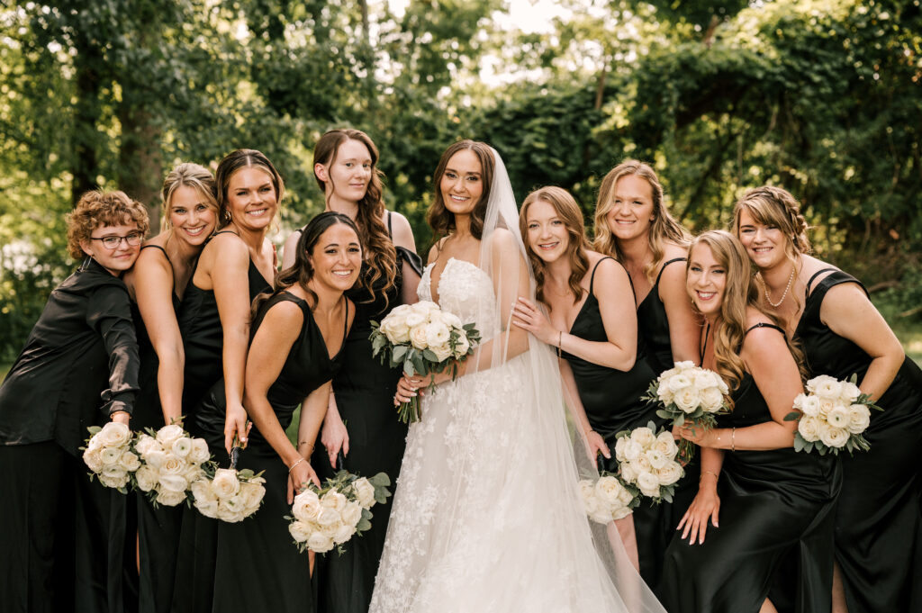 The bridesmaids smiling and posing with the bride at Perona Farms Refinery.