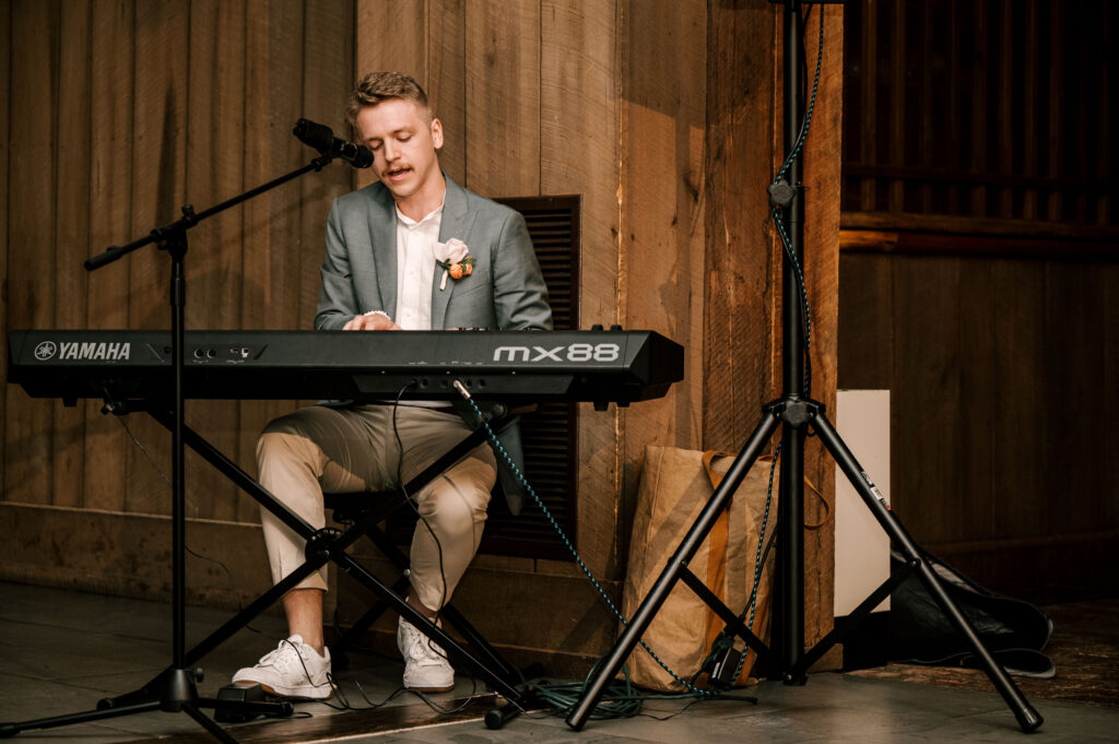 The groom singing a song for his bride at the reception at Waterloo Village.