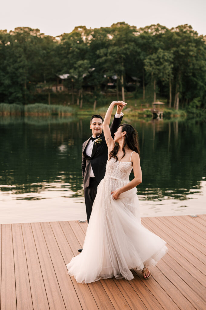 The groom twirling the bride on the dock at Rock Island Lake Club.