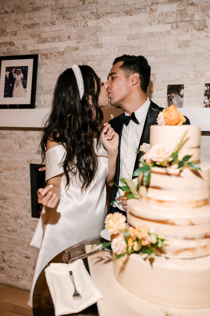 The newlyweds kissing after cutting the wedding cake during the reception at at Rock Island Lake Club.