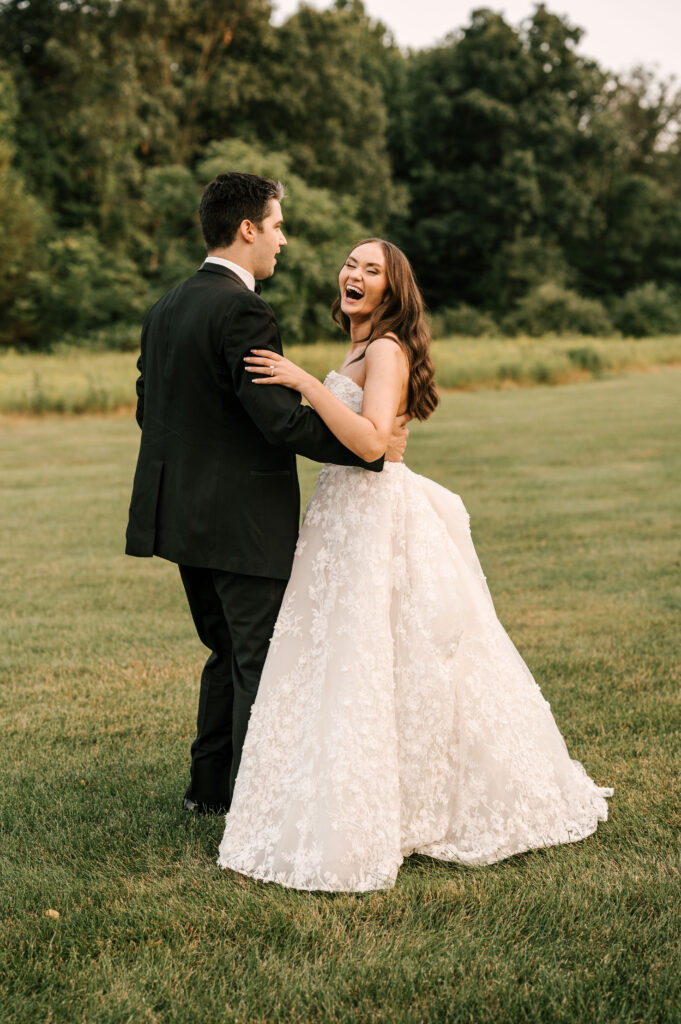 The couple giggling and dancing in a field after the ceremony at Perona Farms Refinery.
