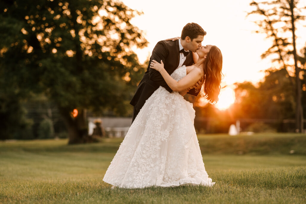 The groom dip-kissing the bride during golden hour at Perona Farms Refinery.