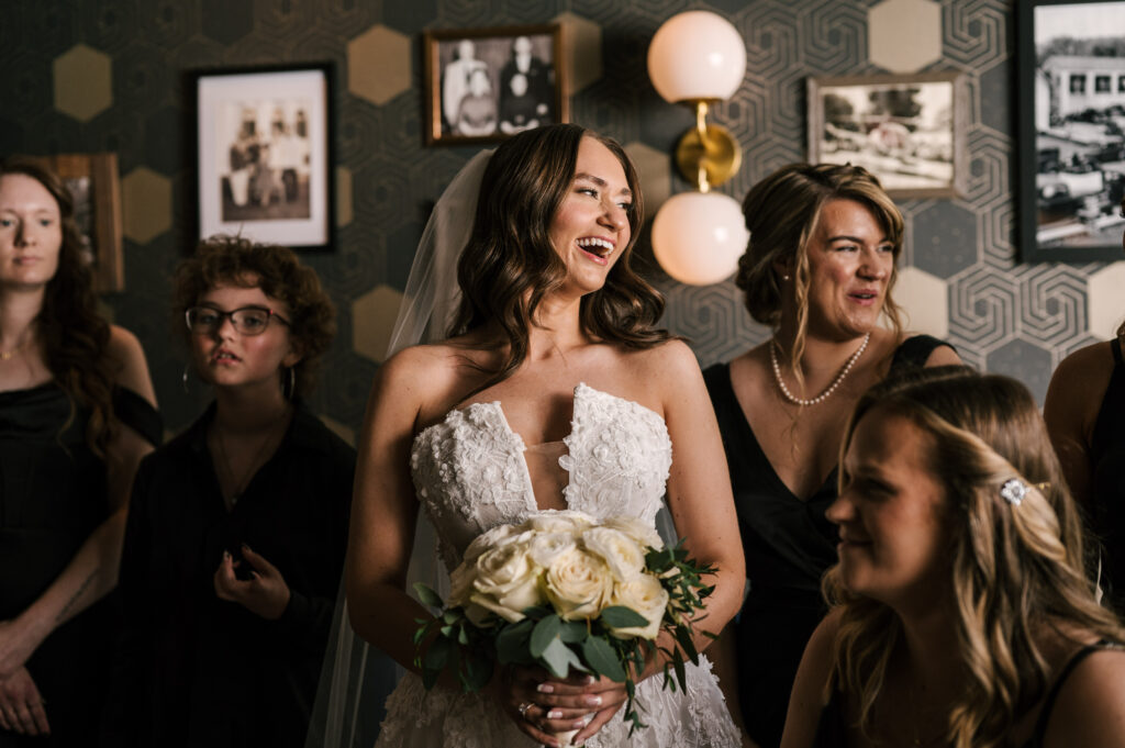 The bride smiling and talking with her bridesmaids at Perona Farms Refinery.