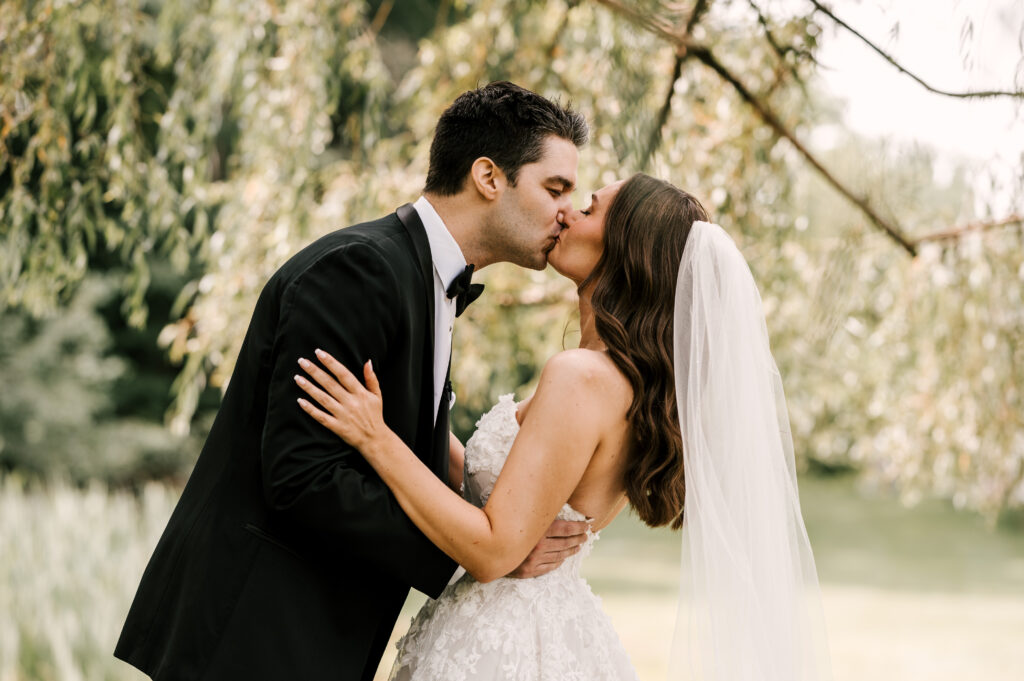 The couple embracing and sharing a kiss outside at Perona Farms Refinery.