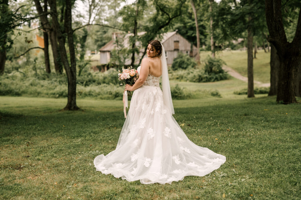 The bride looking down and over her shoulder as she holds her bouquet at Waterloo Village.
