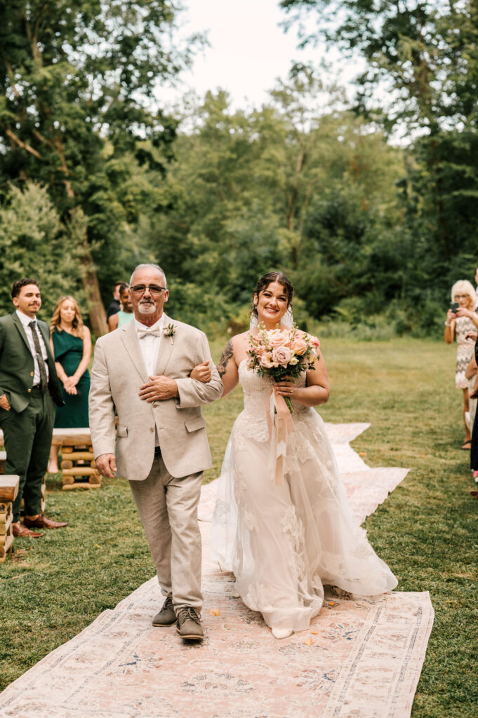 The bride's father walking her down the aisle during the ceremony at Waterloo Village.