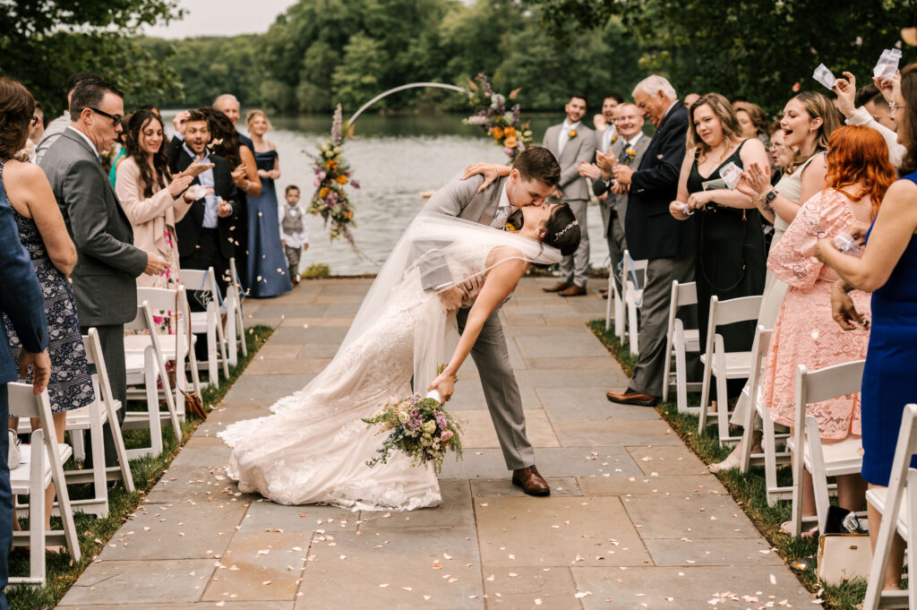 bride and groom dip kiss in the center aisle at their ceremony for indian trail club wedding in Franklin Lakes NJ