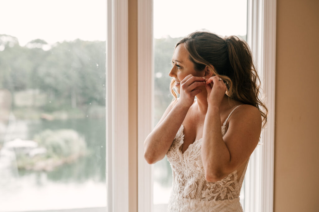 The bride putting on her earrings before the ceremony at Rock Island Lake Club.