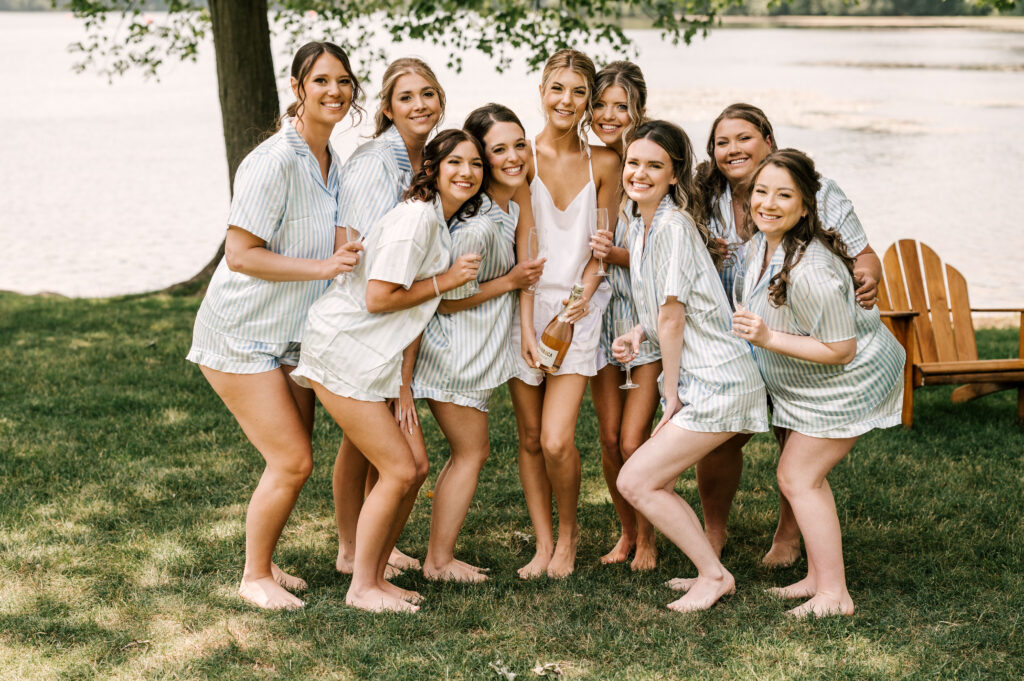 bride and bridesmaids champagne toast by the lake at indian trail club
