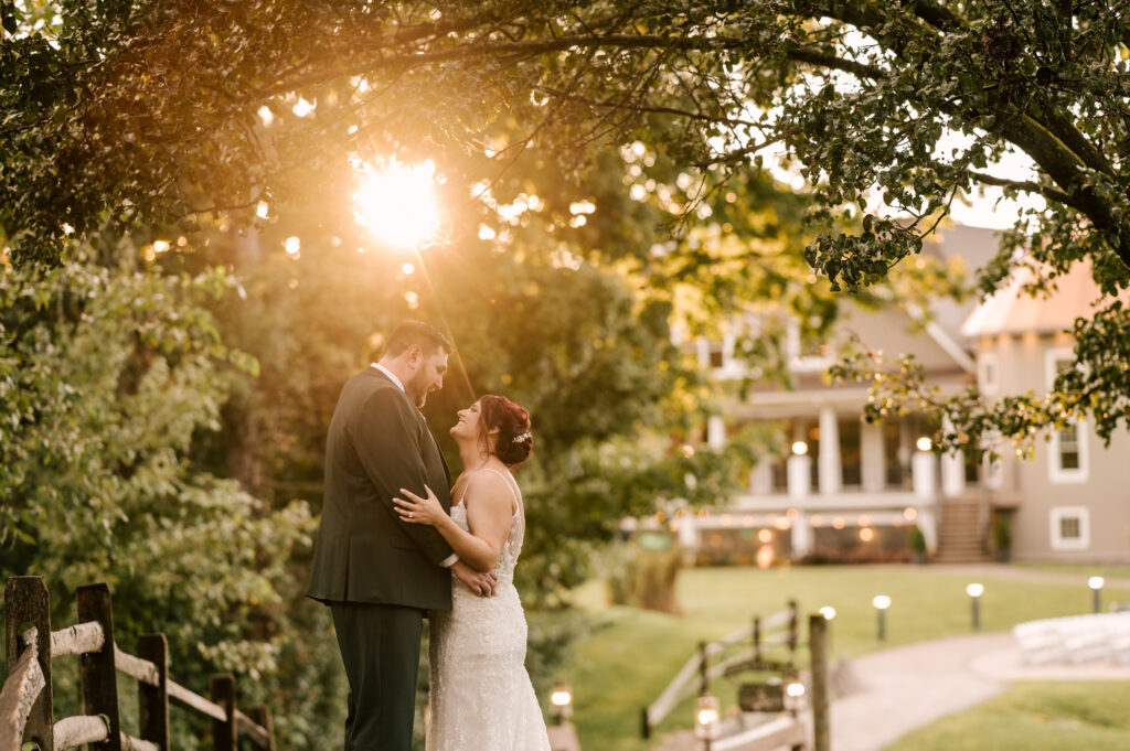 sunset at Bear Brook Valley wedding venue in fredon township nj. couple embracing on the bridge