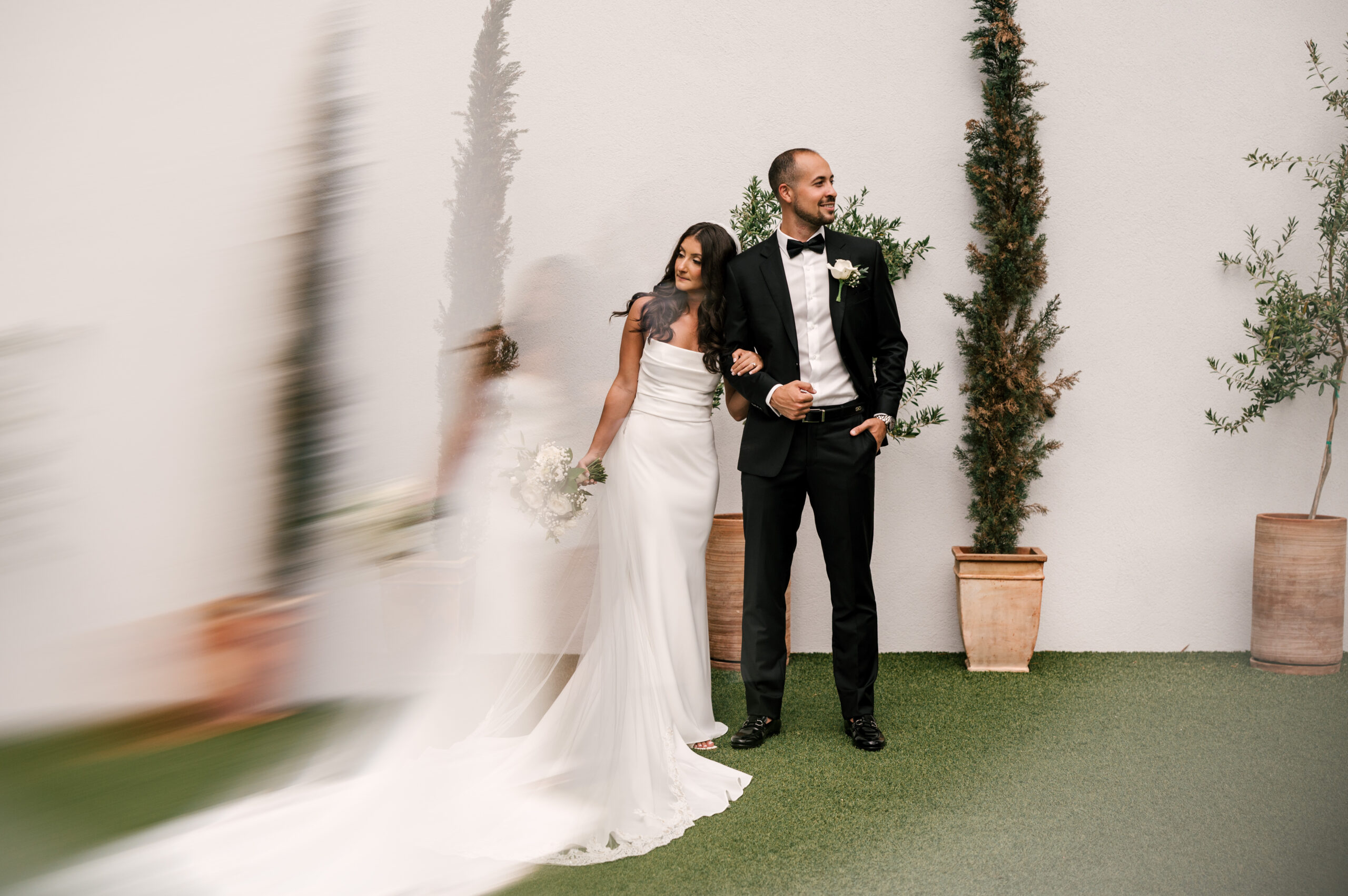 The bride and groom standing arm in arm before their ceremony at Perona Farms Reserve.