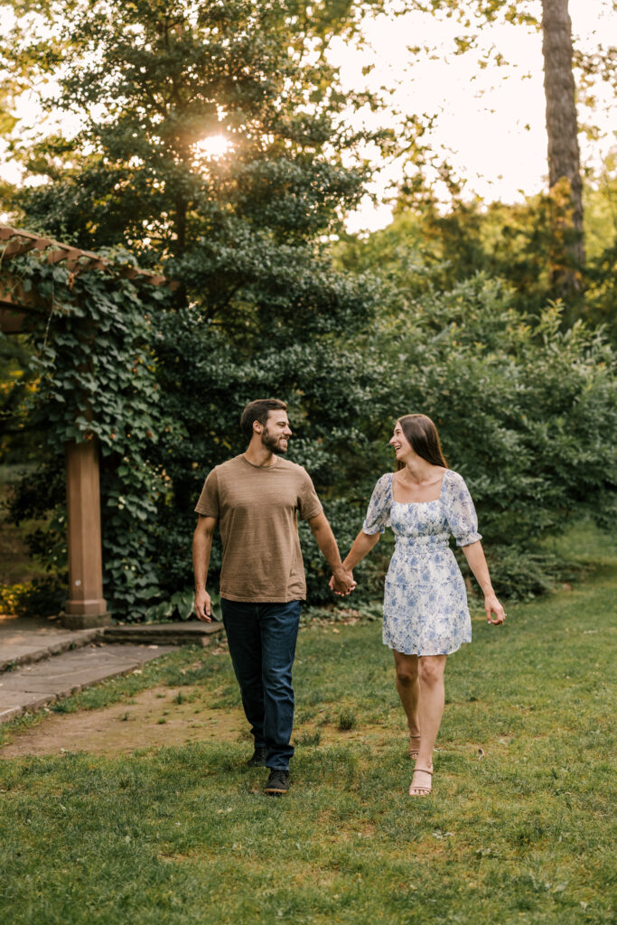 Bride and groom to be holding hands in the sunset at Van Vleck Gardens