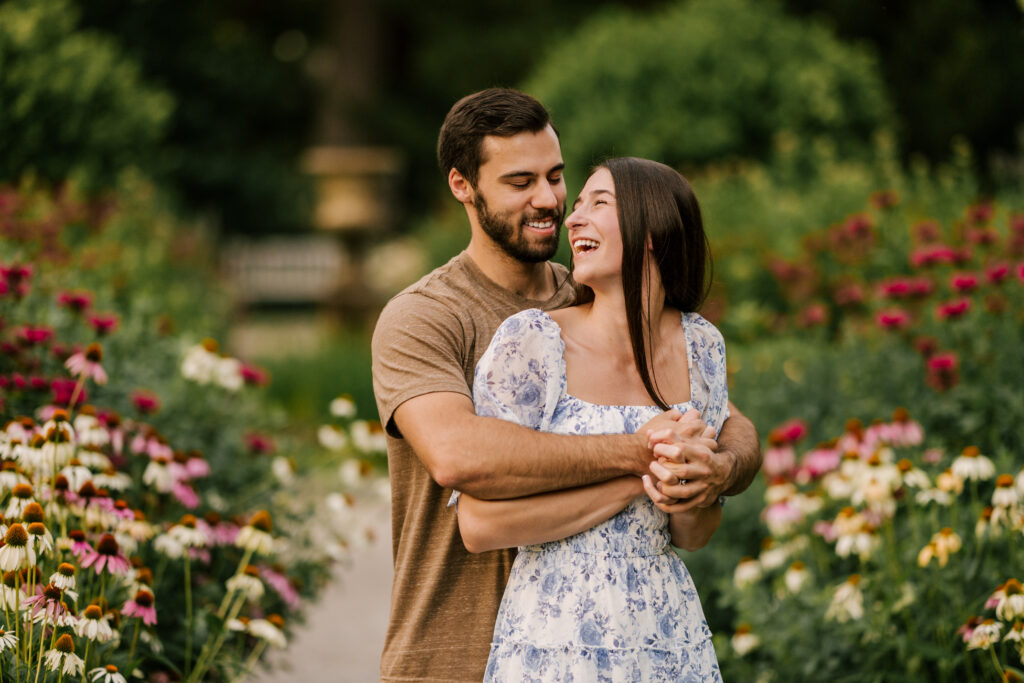 bride to be laughing with future husband in a flower field