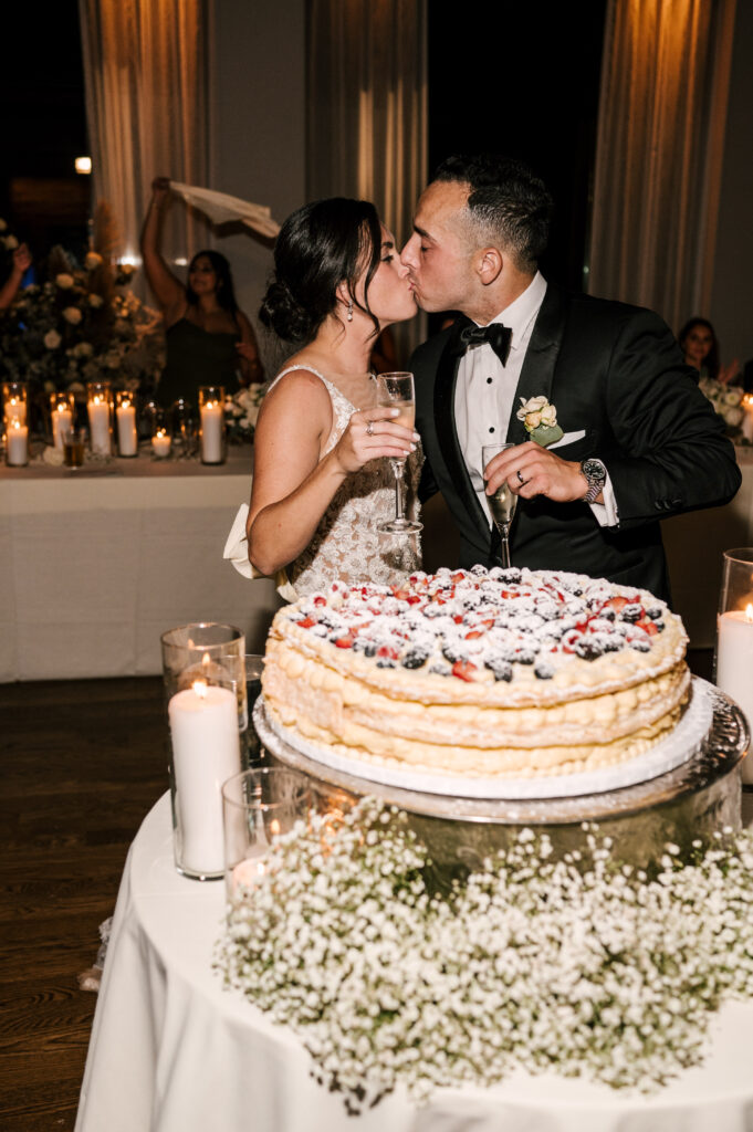 bride and groom sharing a kiss during their cake cutting at september long island ny wedding