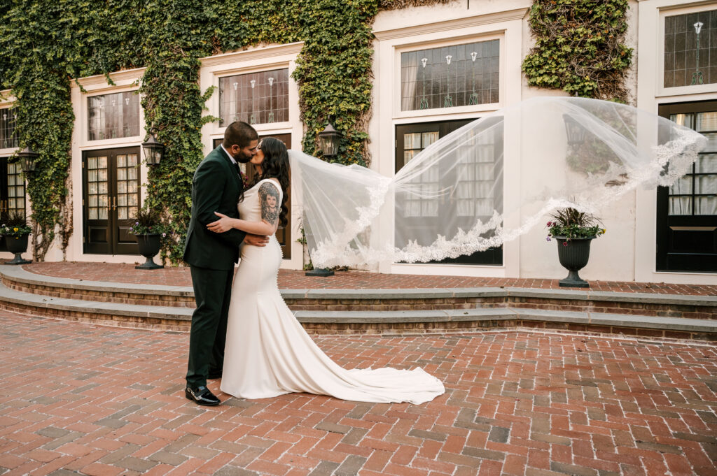 bride and groom kissing in front of venue during fall nj wedding