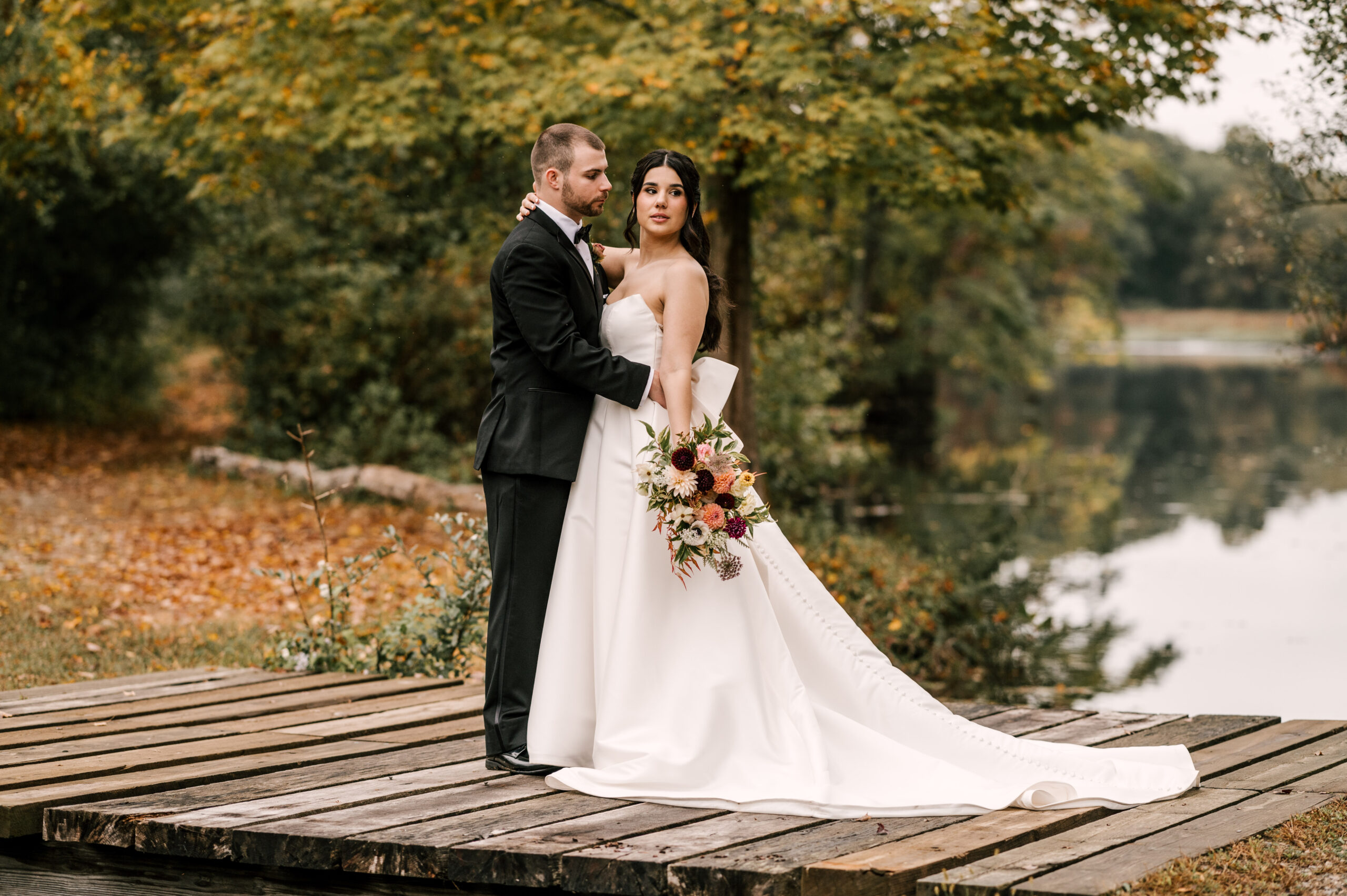 bride and groom on wooden dock overlooking lake at waterloo village nj wedding