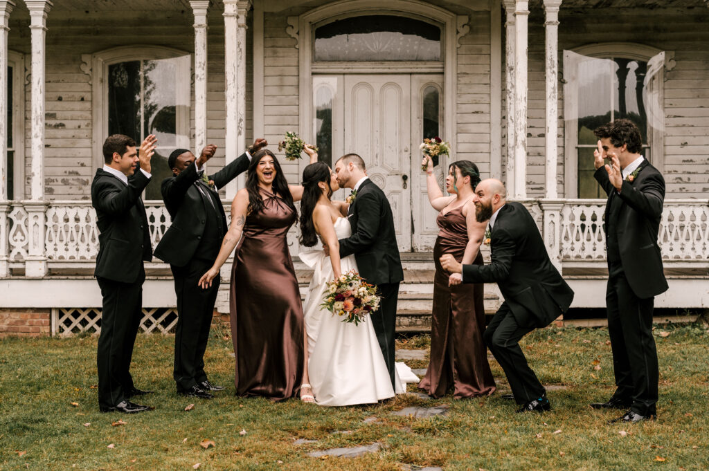 bride and groom with wedding party in front of historical building at waterloo village nj wedding venue