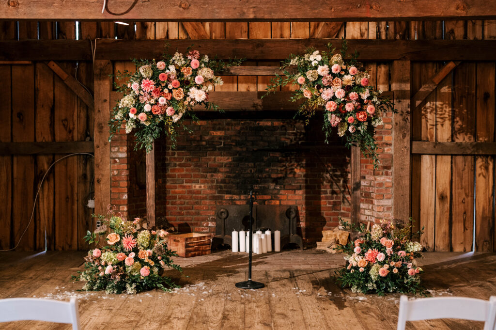 ceremony space at waterloo village with wooden beams, pink florals and lots of candles