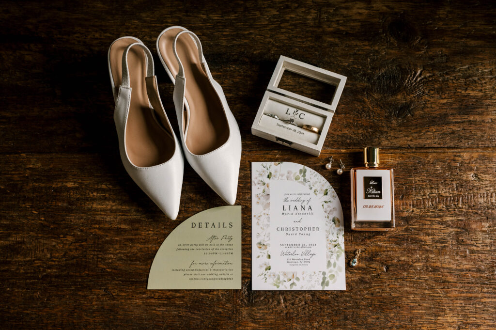 detail photograph with invitation suite, perfume and bridal shoes at waterloo village september wedding