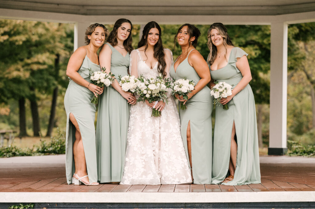 bridal party in green dresses from azazie with bride