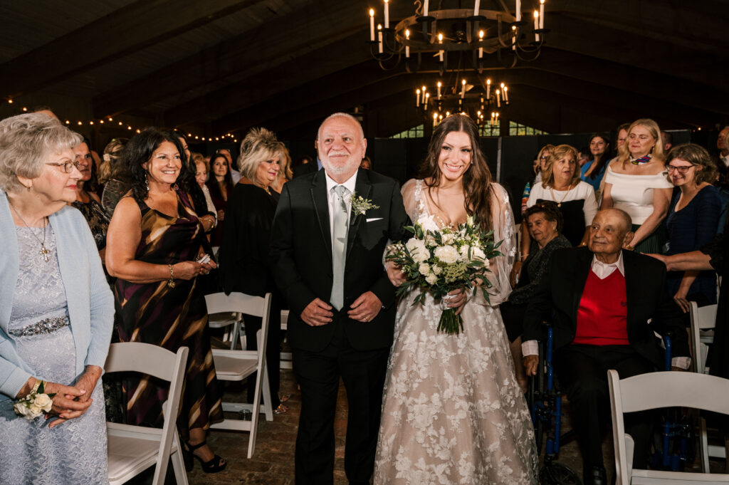 bride and her father walking down the aisle during the waterloo village wedding ceremony in nj
