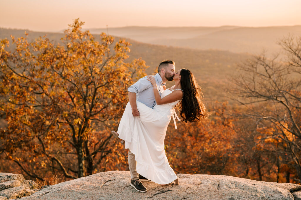 couple dip kiss in fall foliage october engagement
