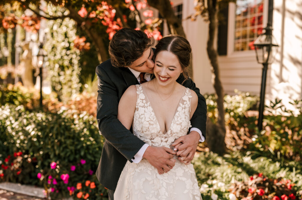 groom kissing the bride's cheek while they hold hands and share laughs at their nj october wedding