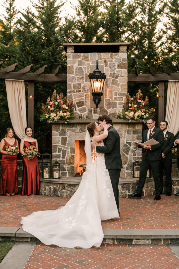 bride and groom sharing their first kiss as a married couple at david's country inn in nj for their october wedding
